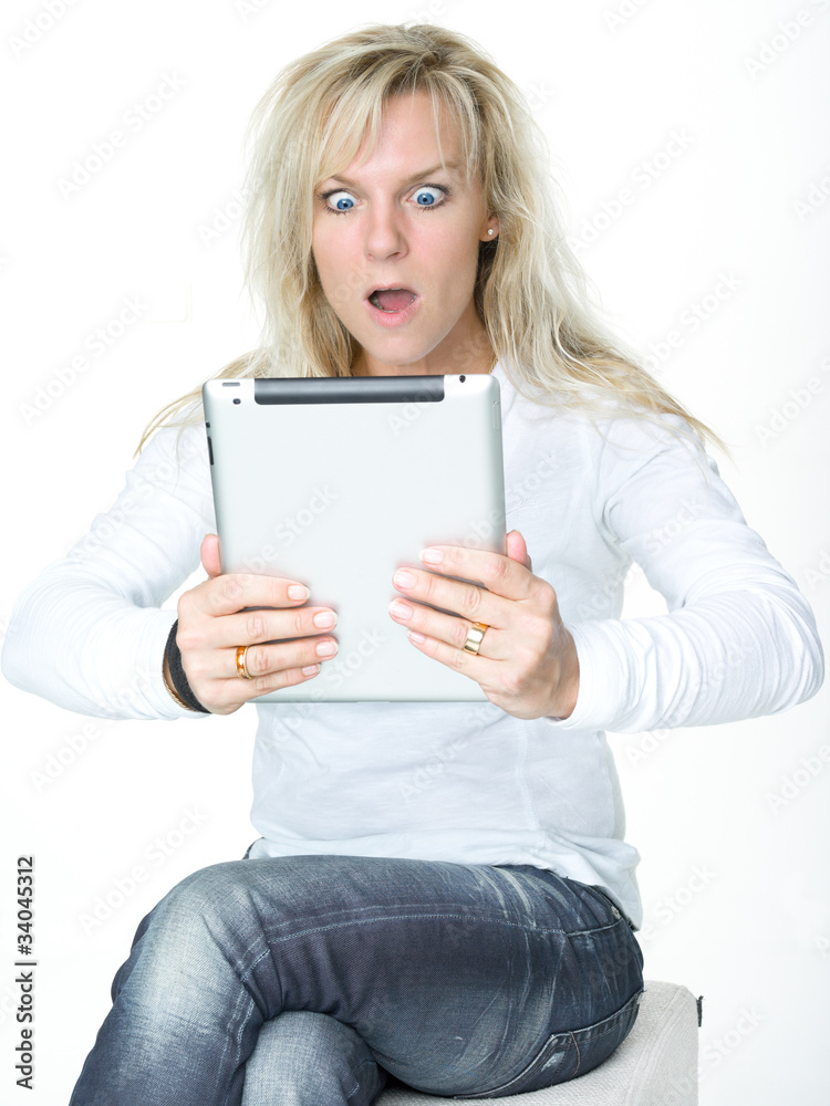 Surprised woman surfing on the internet with touchpad Surprised woman surfing on the internet with touchpad