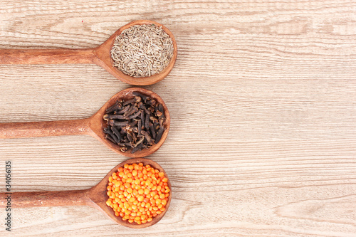 spices in the spoons on wooden background