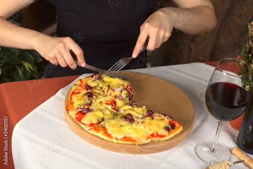 Woman eating vegetarian pizza in a pizzeria