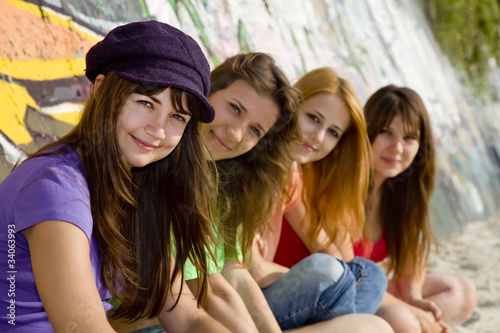 Four girlfriends near graffiti wall.