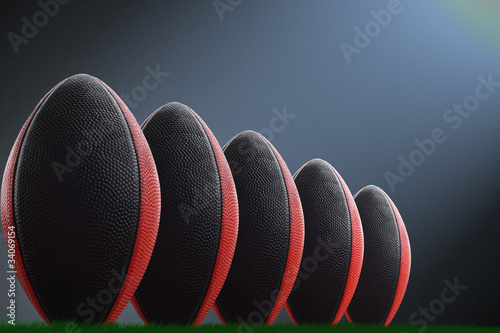American fotballs in a row on a dark-blue background and light photo