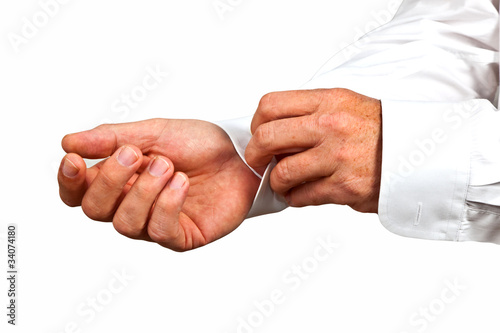 man closing the sleeve of the white shirt © travelview