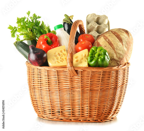 Groceries in wicker basket isolated on white
