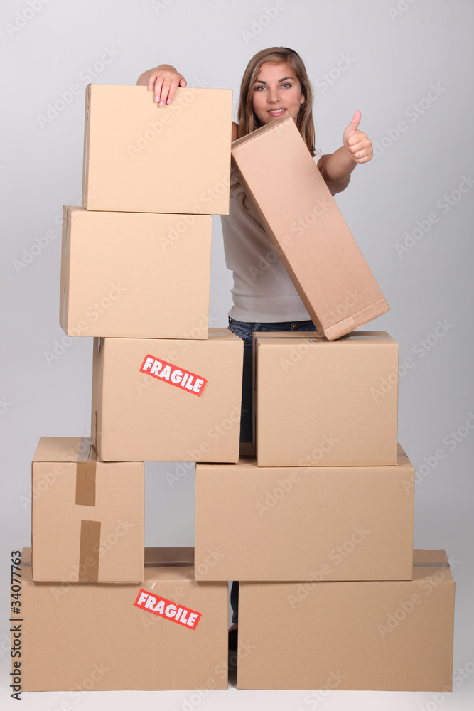 Woman behind a pile of cardboard boxes Woman behind a pile of cardboard boxes