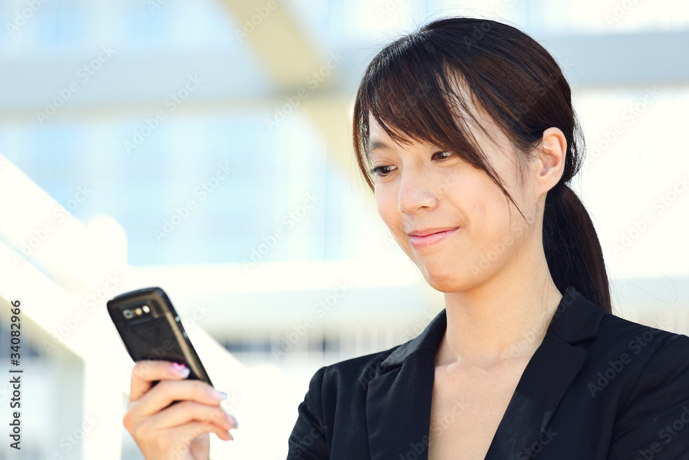 Business woman sending text message on mobile phone Business woman sending text message on mobile phone