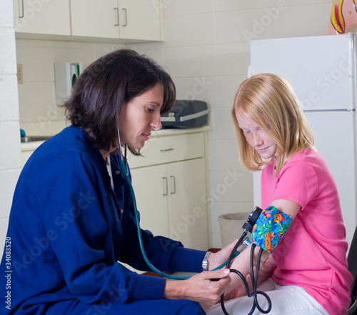 School nurse checking blood pressure