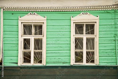 Деревянные окна и резные наличники на фасаде дома