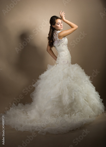 The beautiful young woman posing in a wedding dress