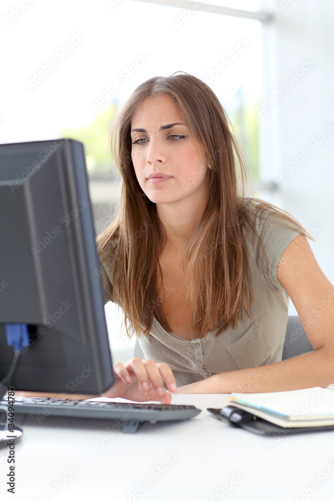 Young woman working on desktop computer Young woman working on desktop computer