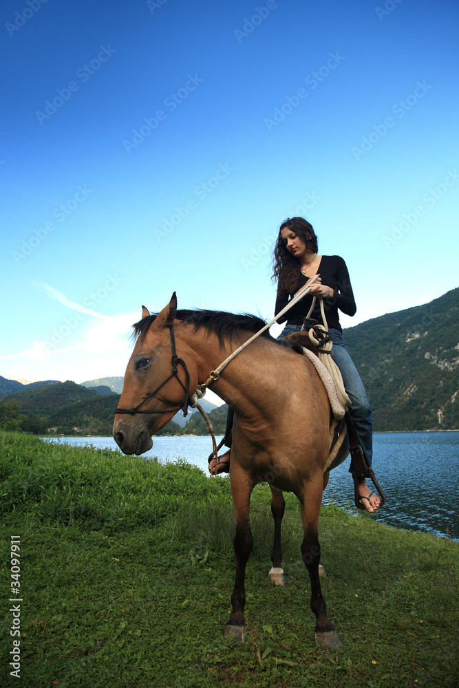 ragazza a cavallo in riva al lago in primavera