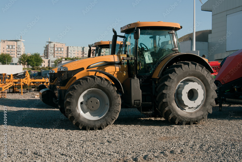 Wheelred modern yellow tractor on parking lot Wheelred modern yellow tractor on parking lot