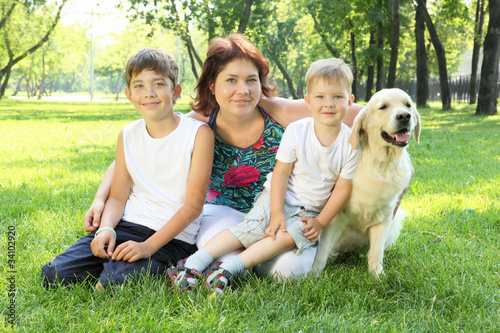 Mother and her two sons in the park with a dog © Sergey Nivens