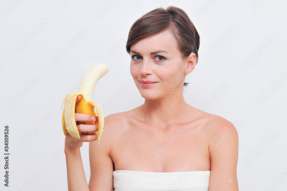 Young beautiful woman in white with banana in hands