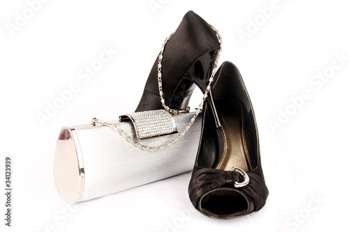 Black high heel women shoes and a silver clutch.