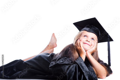 Dreaming girl in graduation dress on isolated white