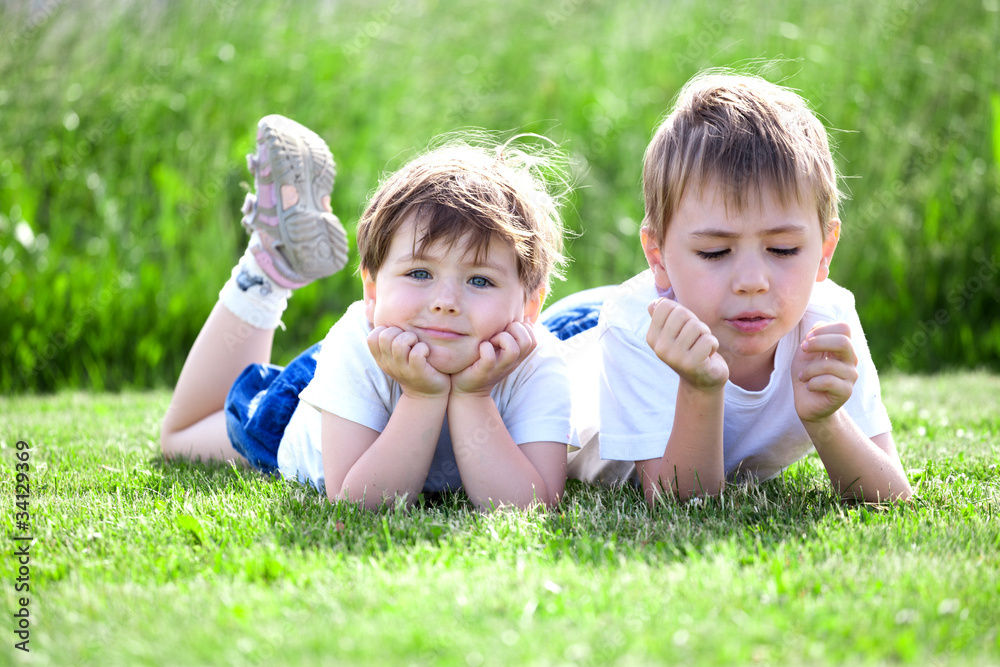 siblings lying on grass siblings lying on grass