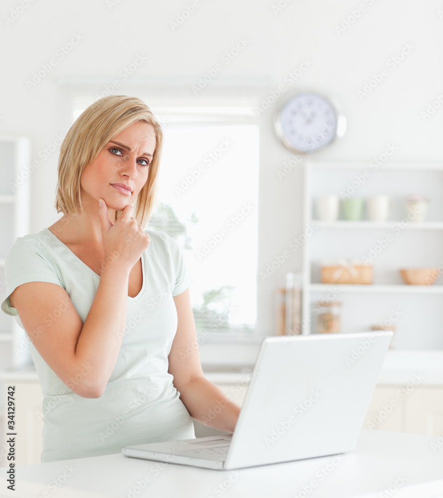 Wondering blonde woman looking at notebook Wondering blonde woman looking at notebook