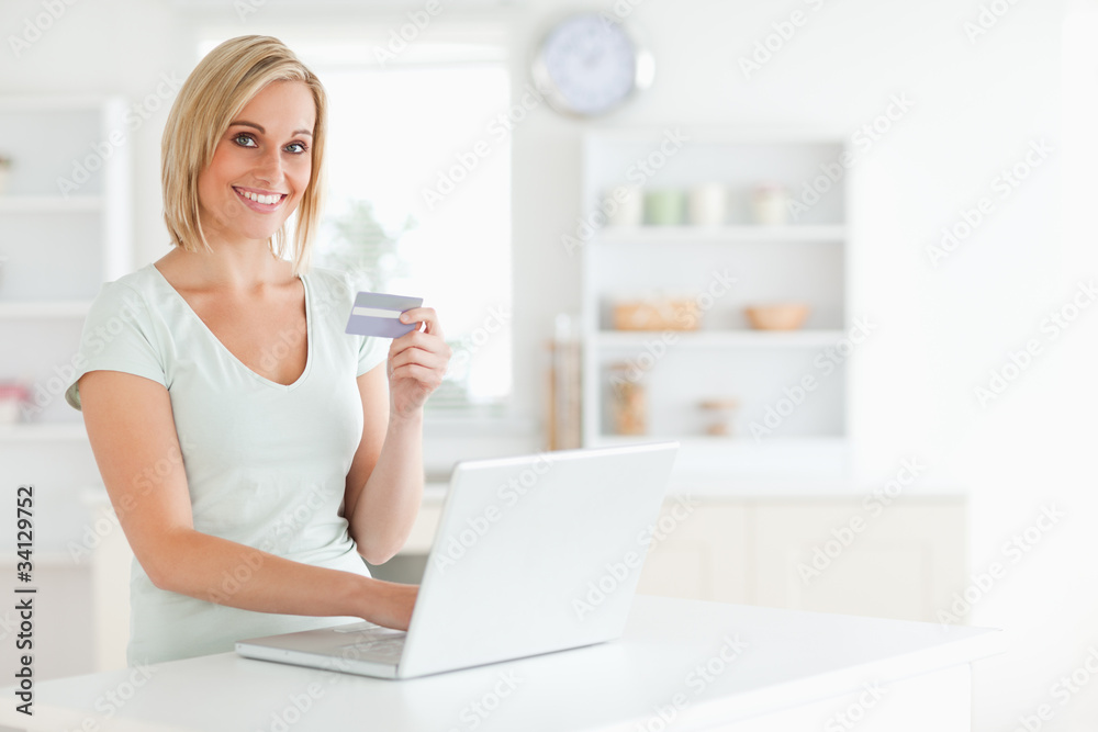 Woman with credit card and notebook looks into camera Woman with credit card and notebook looks into camera
