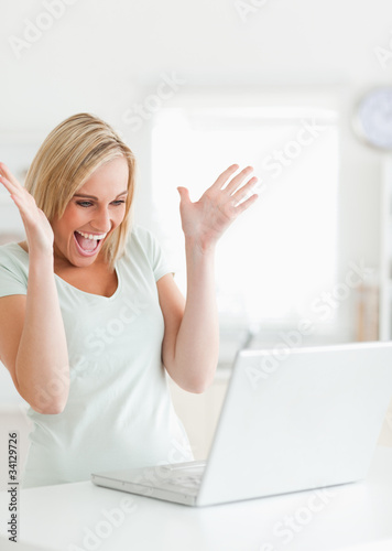 Laughing gorgeous woman looking at laptop