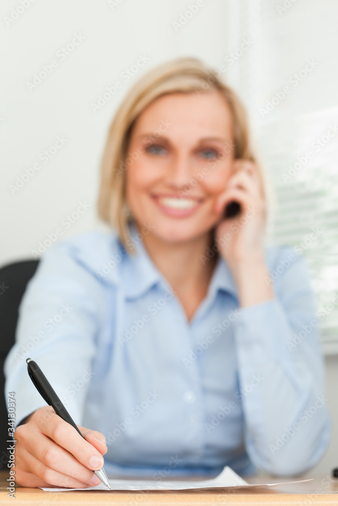 Portrait of a cute businesswoman on mobile noting something look Portrait of a cute businesswoman on mobile noting something look