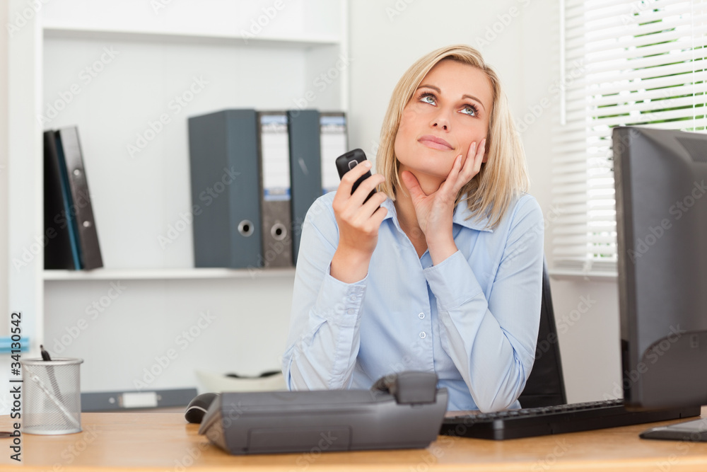 Smiling businesswoman with mobile looking at the ceiling Smiling businesswoman with mobile looking at the ceiling
