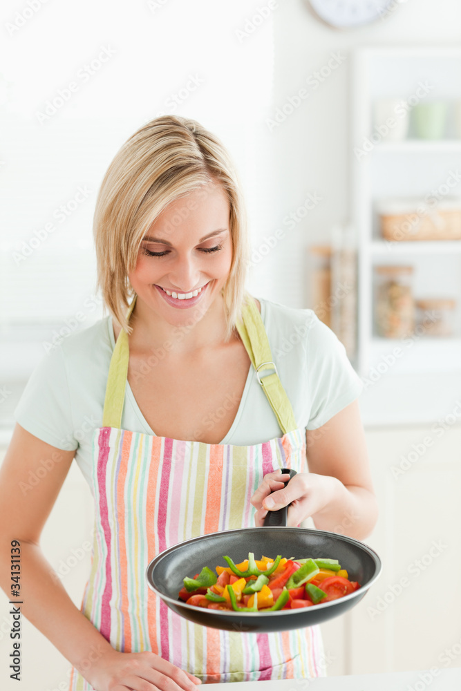 Cute woman looking at pan filled with peppers Cute woman looking at pan filled with peppers