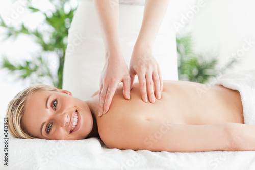 Blonde smiling woman relaxing on a lounger during massage