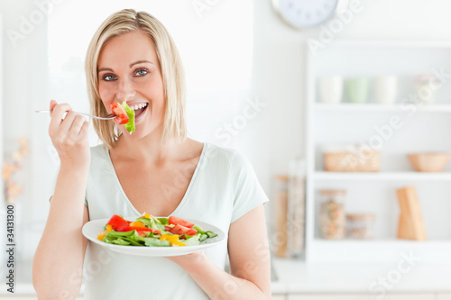 Close up of a charming woman enjoying mixed salad