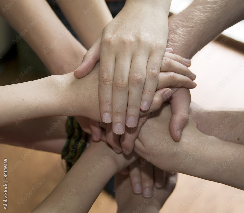 People placed their hands one on the other People placed their hands one on the other