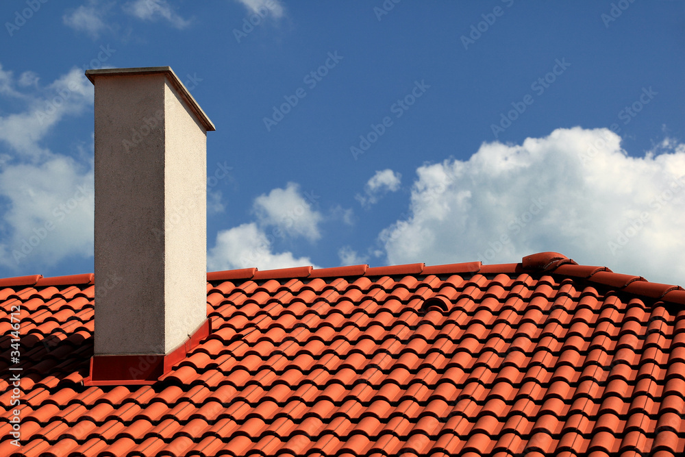 Naklejka premium Red tiles roof and chimney with blue sky