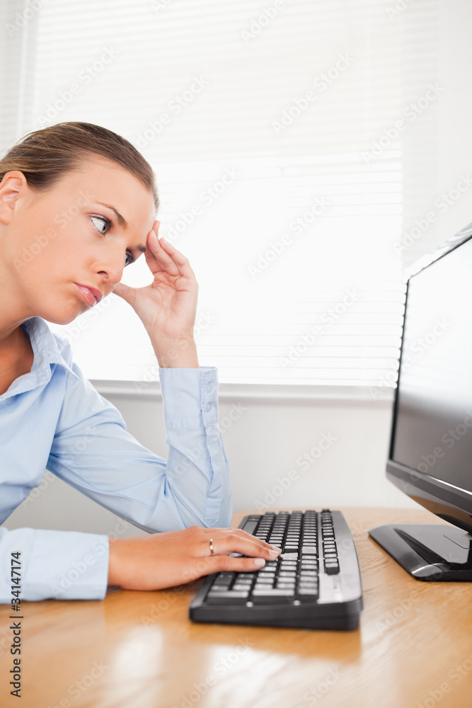 Sad businesswoman looking to screen of her pc Sad businesswoman looking to screen of her pc