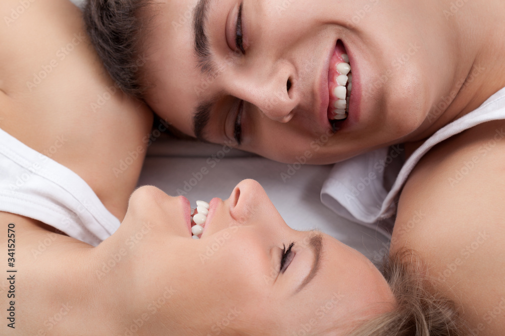 couple lying on white bed