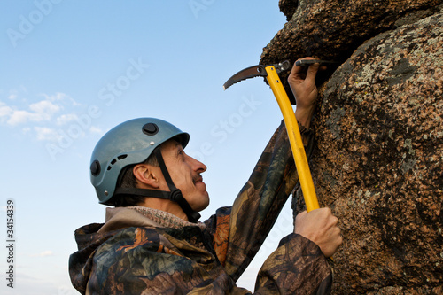 The climber hammers in hook into rock