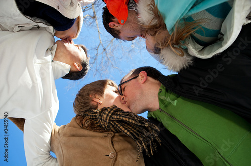 Kiss of three adult couples, view from below