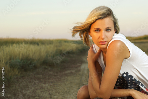 Pretty girl with a suitcase on a countryside road