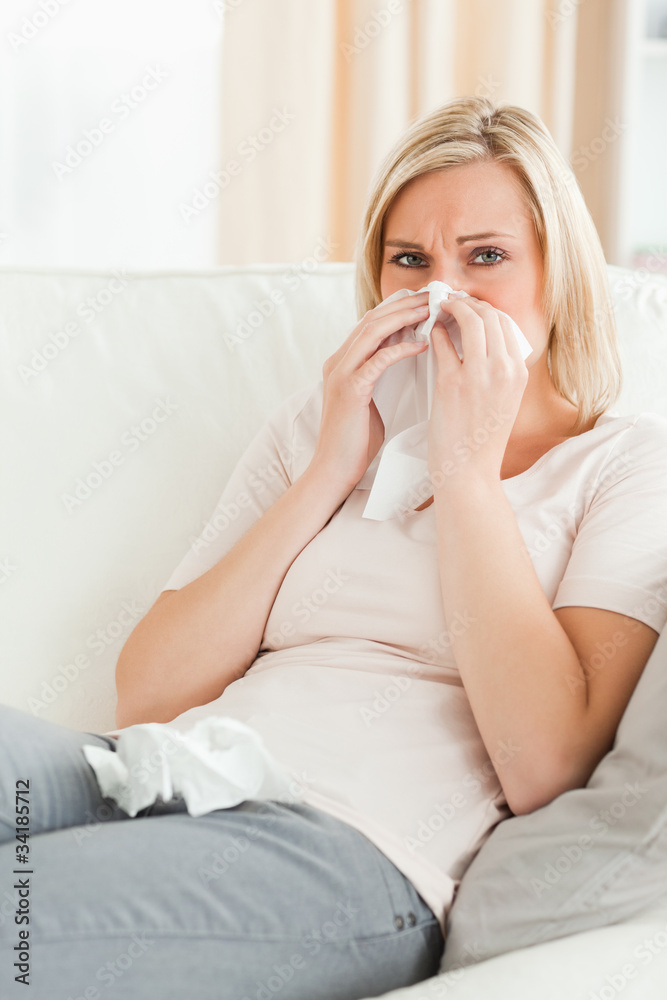 Portrait of a sick woman blowing her nose Portrait of a sick woman blowing her nose