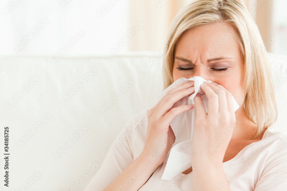 Ill woman blowing her nose