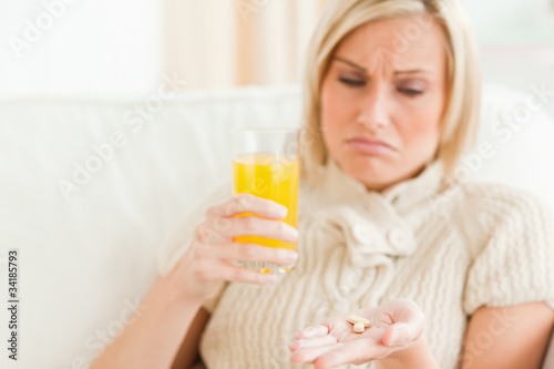 Close up of a sad woman showing pills