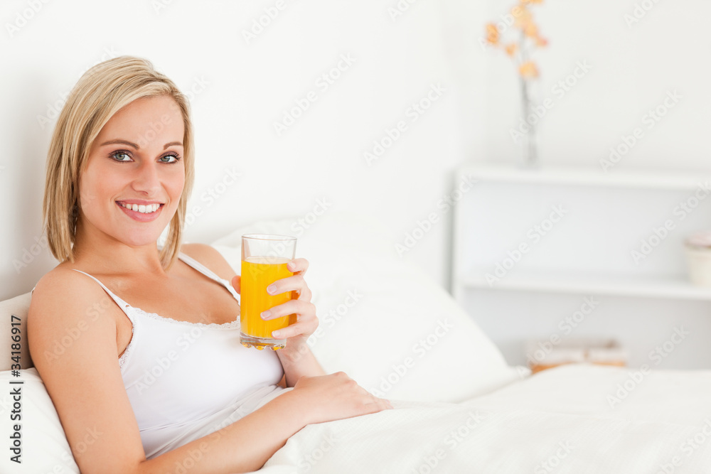 Blonde woman drinking orange juice Blonde woman drinking orange juice