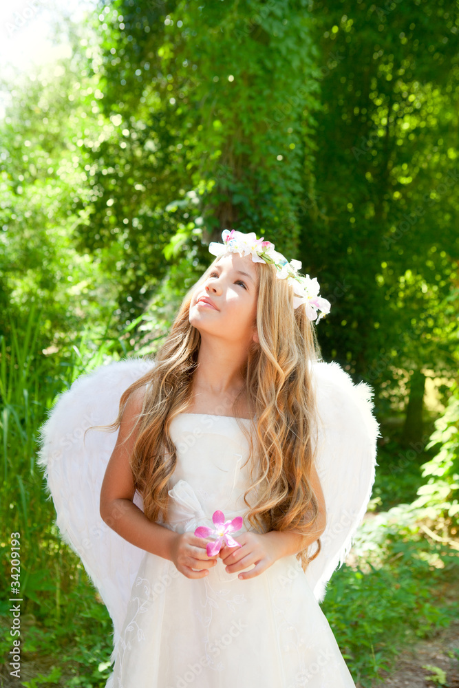 Angel children girl holding flower in hand looking sky Angel children girl holding flower in hand looking sky
