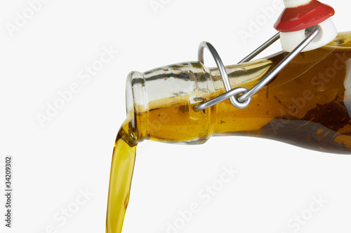 Pouring olive oil isolated on white background