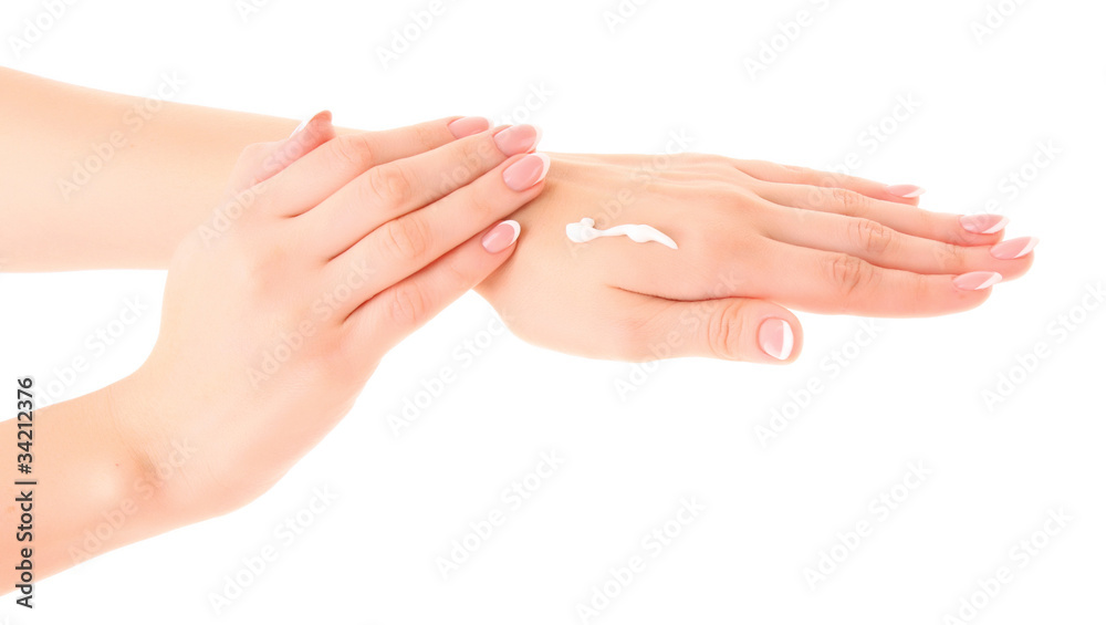 Closeup of beautiful female hands applying hand cream  on white