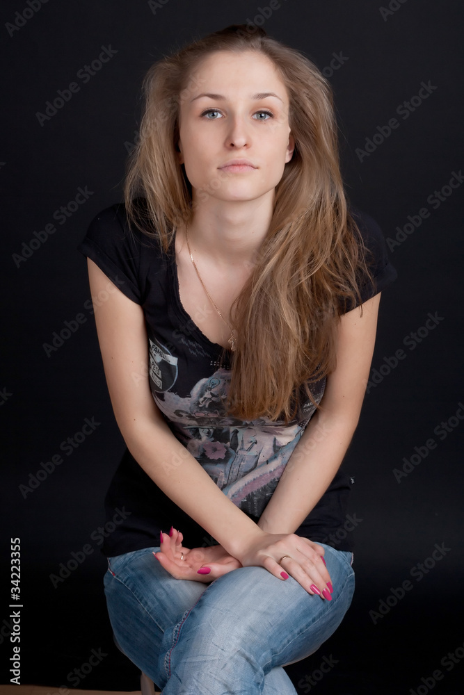 Fototapeta premium Smiling girl sitting on a stool