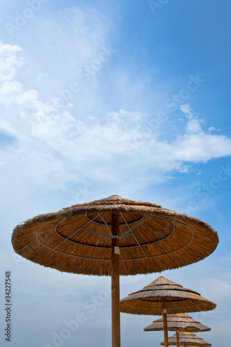 straw parasols and blue sky