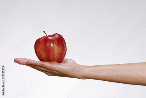 Sosteniendo una manzana roja.