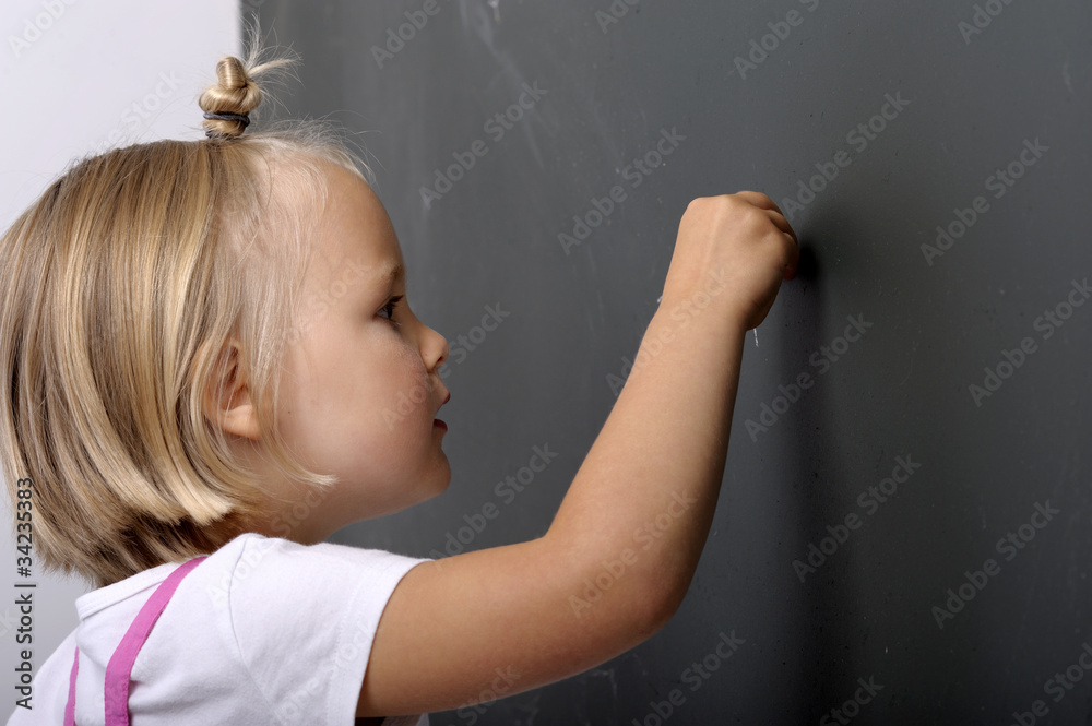 Little girl writing on a chalk board Little girl writing on a chalk board