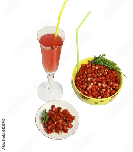 Ягоды земляники в тарелке, блюдце и стакан сока