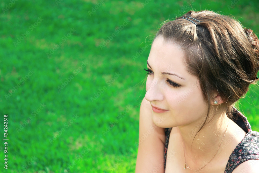 Beautiful girl looking at on green grass background on sunny day Beautiful girl looking at on green grass background on sunny day