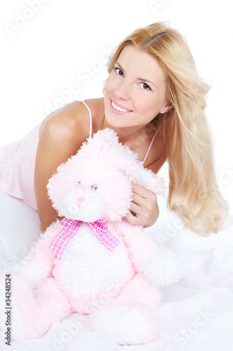 Happy young woman with toy on the bed