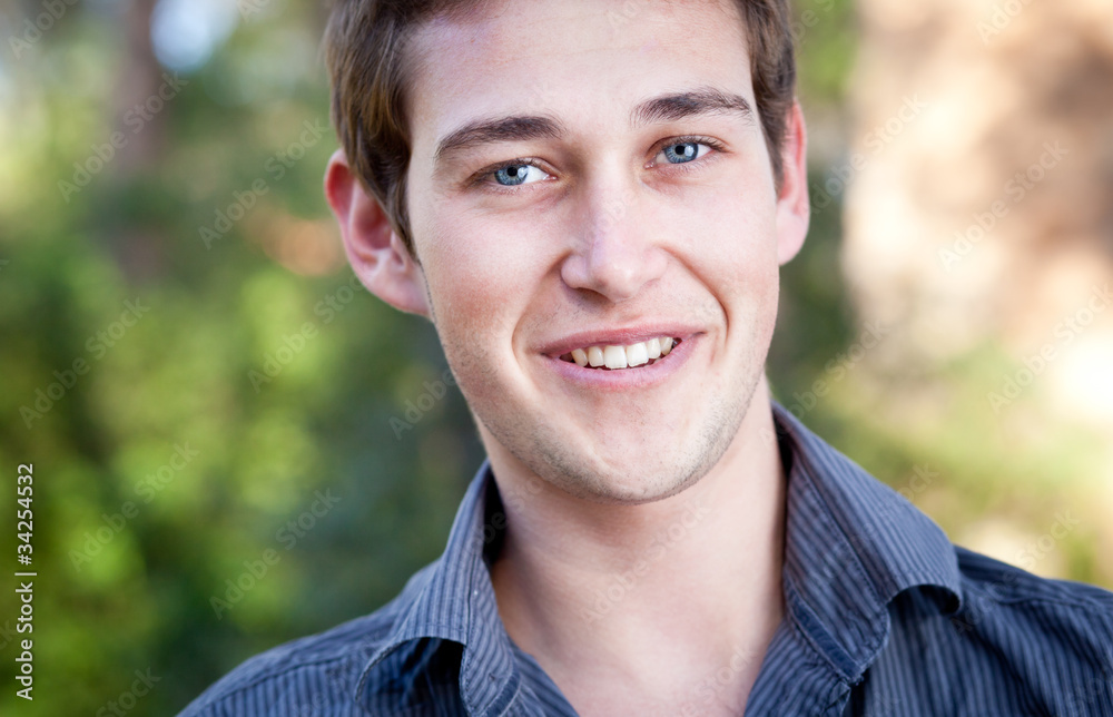 close-up portrait of a casual handsome man smiling while outdoor close-up portrait of a casual handsome man smiling while outdoor